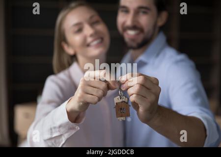 Cheerful satisfied couple of apartment buyers holding keys together Stock Photo