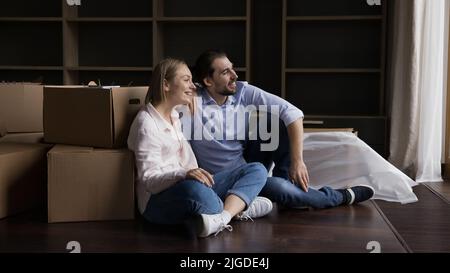 Cheerful dreamy girl and guy relaxing at new home Stock Photo