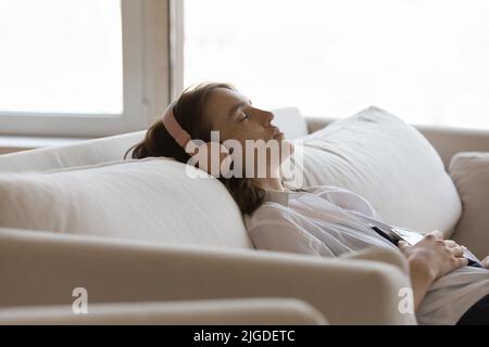 Close up shot relaxed woman in headphones listen music Stock Photo