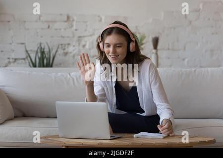 Woman makes videocall, greets tutor, start online class at home Stock Photo