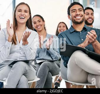 That was great. a group of young businesspeople applauding while sitting in the conference room during a seminar. Stock Photo
