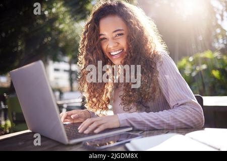 Note taking made easier by my laptop. a young female student using a laptop while studying at a cafe. Stock Photo