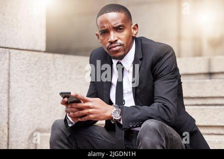 Be serious about your connections. Cropped portrait of a handsome young businessman checking his messages during his lunch break. Stock Photo