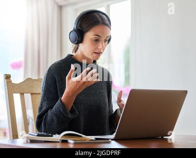 Working remotely is a breeze thanks to technology. an attractive young female entrepreneur working on her laptop at home. Stock Photo