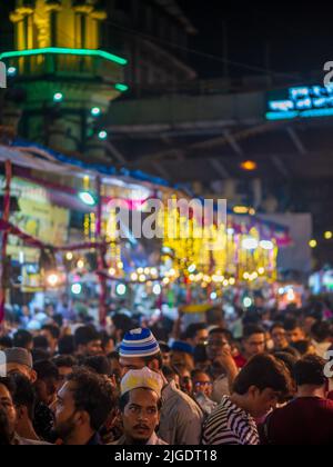 Mumbai, India - May 1, 2022 : Crowd gathered to tests Ramzan or Ramadan feast at night market.Vertical or portrait orientation Stock Photo