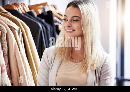 Looking for the latest and greatest in the fashion world. a young woman shopping in a retail store. Stock Photo