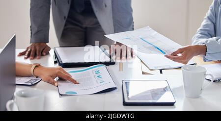 Lay it all out on the table. a group of businesspeople discussing paperwork on a table. Stock Photo