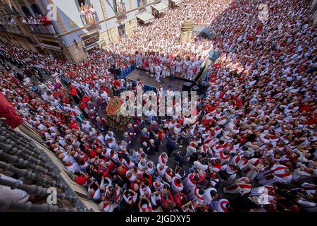 People attend the San Fermin procession during the traditional San Fermin festivities in Pamplona, Spain, 07 July 2022. The festival, known locally as Sanfermines, is held annually from July 6 to 14 in commemoration of the patron saint of the city. Hundreds of thousands of visitors from all over the world attend the festival. Many of them physically participate in the most prominent event, the bullfight or encierro, where they try to escape from the bulls along a route through the narrow streets of the old city.  (Photo by Ruben Albarran / PRESSINPHOTO) Stock Photo