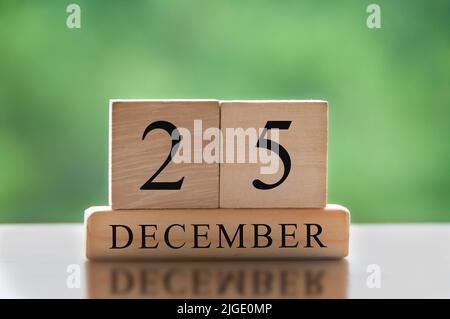 December 25 text on wooden blocks with blurred nature background. Copy ...