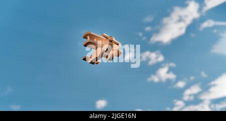 Wooden toy light aircraft biplane flying in the cloudy sky. Copy space. Banner Stock Photo