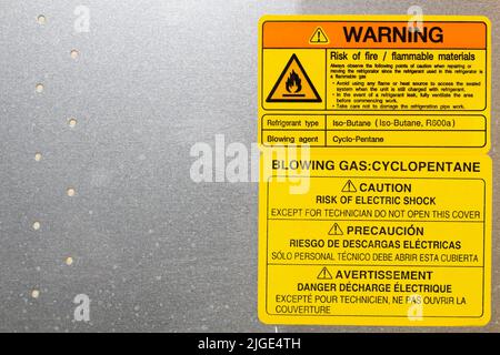 Warning. Blowing gas. Cyclopentane. Blowing agent.  Warning label on household appliances. Refrigerator repair in the workshop. Service maintenance. Stock Photo