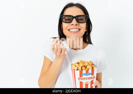 Portrait of joyful young woman wearing 3d glasses eating popcorn, white background Stock Photo