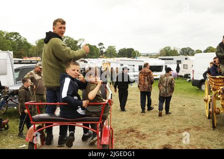 A family sitting in a trap at Appleby Horse Fair, Appleby in Westmorland, Cumbria Stock Photo