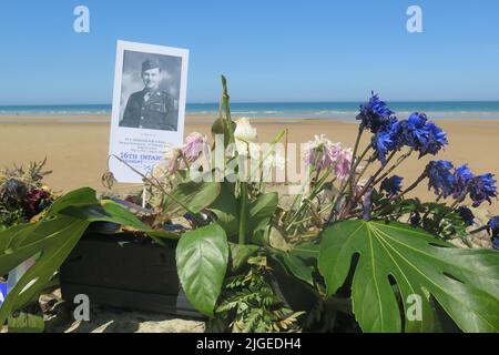 Flowers and a photo on a memorial stone commemorate medic Edward Morozewicz, killed at Omaha Beach on 6 June 1944, aged 22, Arromanches-Les-Bains, Fra Stock Photo