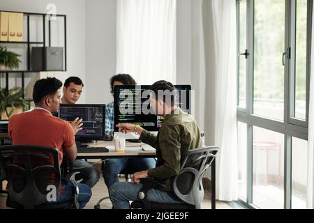 Software developers discussing programming code and planning how to create innovative software Stock Photo