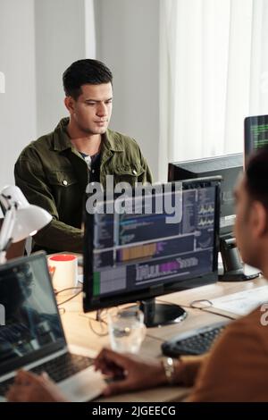 Concentrated young Indian software developer working on computer in open space office Stock Photo