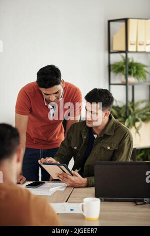Developers collaborating on project of new application for tablets Stock Photo