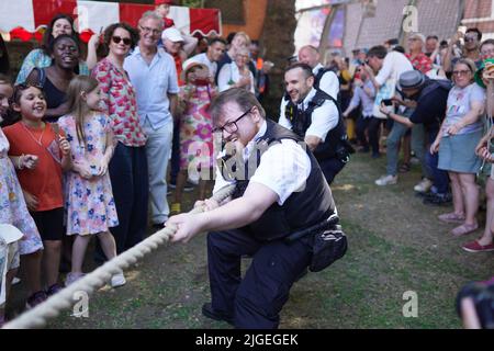 Police versus the Fire Brigade at the Soho Village Fete, Wardour Street, London. A dog show, a spaghetti eating contest and the famous Soho Waiter's Race are all part of the festivites at the fete. Picture date: Sunday July 10, 2022. Stock Photo