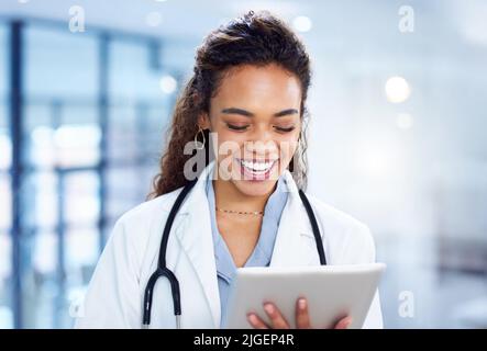 Laughter is the best medicine. a young doctor using a digital tablet in a modern hospital. Stock Photo