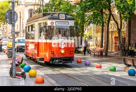 Tram in Kadikoy district, on high street, with colorful rail barriers. Istanbul, Turkey Stock Photo