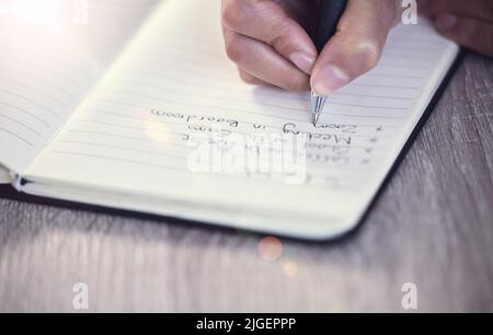 Planning out my day. an unrecognizable call center agent at work. Stock Photo