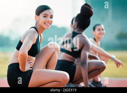 For the love of the race. Cropped portrait of an attractive young sportswoman on a running track with her fellow athletes. Stock Photo
