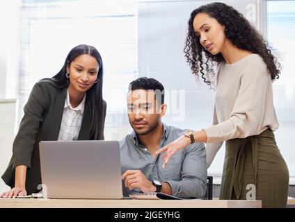 We create the best projects together. a group of businesspeople using a laptop at work. Stock Photo