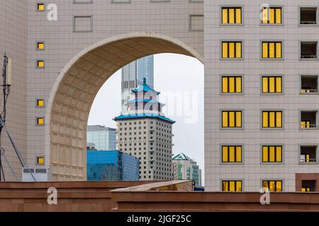 Nur Sultan (Astana), Kazakhstan, 11.11.21. Beijing Palace Soluxe Hotel Astana building with traditional Chinese blue roof seen through an arch in gold Stock Photo
