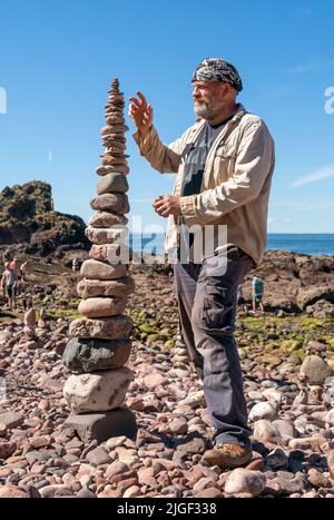 Competitor James Brunt from Sheffield takes part in the 'most stones balanced in 20 minutes' event during the European Stone Stacking Championships 2022 on Eye Cave Beach in Dunbar, East Lothian. The championships are Europe's largest competition for all stone stacking and rock balancing enthusiasts and artists. Picture date: Sunday July 10, 2022. Stock Photo