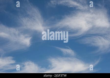 A bright blue sky with white wispy clouds Stock Photo