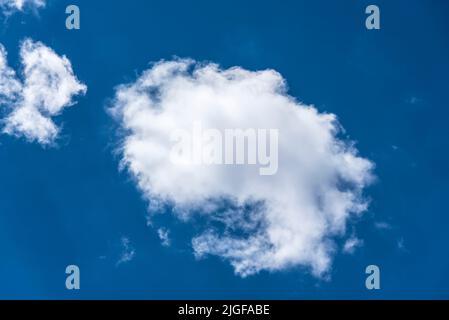 fluffy white stratocumulus clouds in clear deep blue sky on a summer day Stock Photo