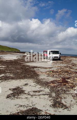 Vans parked on the sand at low tide between Boisdale, South Uist, and the tidal island of Orasay/Orasaigh, Outer Hebrides, Scotland Stock Photo