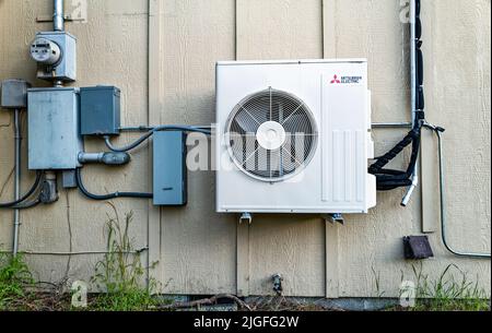 Mitsubishi air conditioner compressor fan installed on the exterior of a building in central Oregon, USA Stock Photo