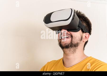 A Latin mid-adult man is wearing a VR Headset and he is happily looking up Stock Photo