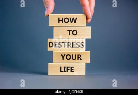 Destress your life symbol. Concept words How to destress your life on wooden blocks. Doctor hand. Beautiful grey background. Psychological business an Stock Photo