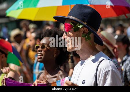 Man wearing hat with flower at Helsinki Pride 2022 Parade in Helsinki, Finland Stock Photo