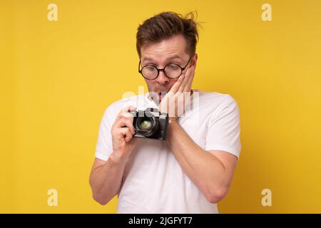 Photographer caucasian man being surprised and shocked looking at camera Stock Photo
