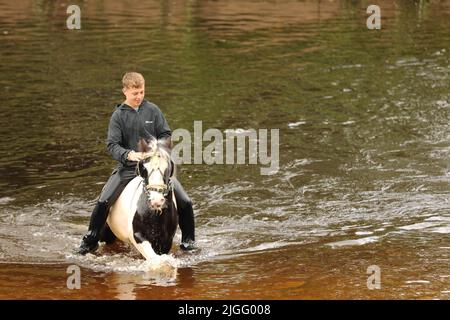 A teenage boy riding his horse in the River Eden, Appleby Horse Fair, Appleby in Westmorland, Cumbria Stock Photo