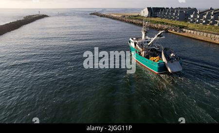 Aerial view of boat along the Manasquan Inlet heading to the Atlantic Ocean In Manasquan, NJ Stock Photo