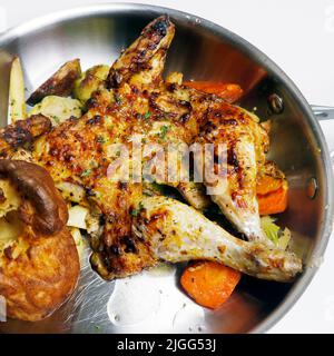 oven roasted or baked baby chicken with vegetables in a metal pan Stock Photo