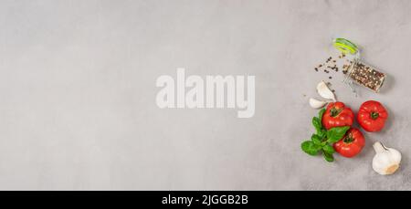 Ripe tomatoes basil garlic gray concrete background. Ingredients fresh vegetables, diet vegetarian Stock Photo