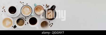 Top view on flat lay with many different full and empty coffee cups composition on gray white concrete background. Variety of tea mug collection layout. Dried coffee beans. Espresso, latte, americano Stock Photo