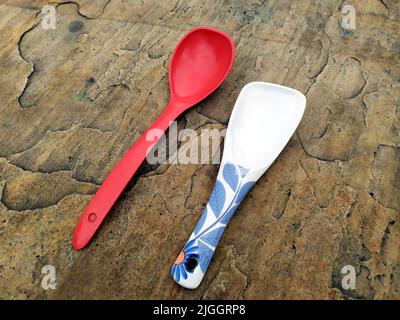 white and red big spoon on the stone background Stock Photo