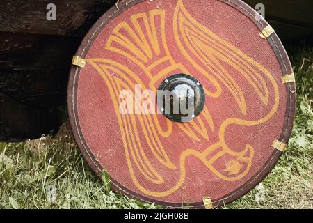 Red vintage shield with with the phoenix bird a medieval warrior. Reconstruction of the events of the Middle Ages in Europe Stock Photo