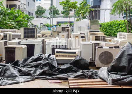 A lot of Air conditioners stacked up in a pile to disposal at recycling garbage dump. Stack of old and dirty air conditioners defective and discarded Stock Photo