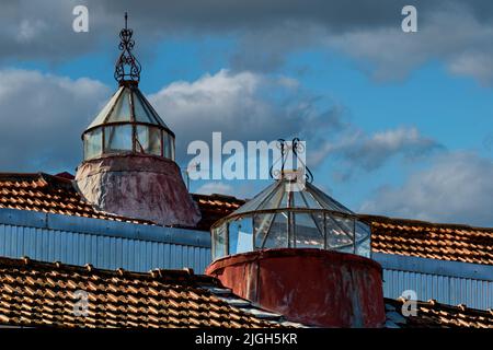 traditional glass skylights topped with a wrought iron spire on a roof in Porto, Portugal Stock Photo