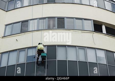 Window washer cleaning building facade. work at height. industrial mountaineering. high-rise window washing Stock Photo