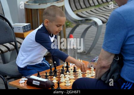 Non Exclusive: VINNYTSIA, UKRAINE - JULY 10, 2022 - Five-year-old chess prodigy Artem Kucher plays with a man during a charity chess match in support Stock Photo