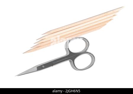 Orange wood cuticle sticks and manicure scissors isolated on white background. Nail beauty and care essential tools. Stock Photo