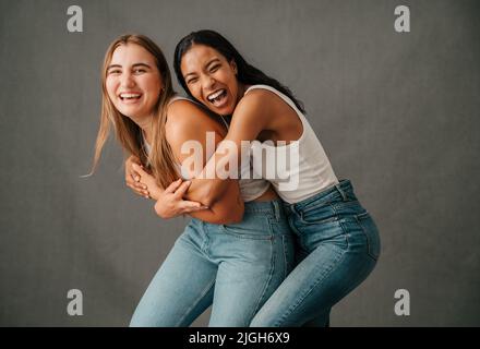 Two female friends smiling and laughing playing around and having fun Stock Photo